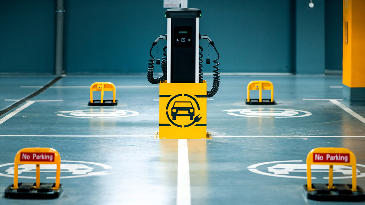 View of an e-fueling station in a parking garage. “No Parking” signs hint at the question: Are EV’s really more sustainable?