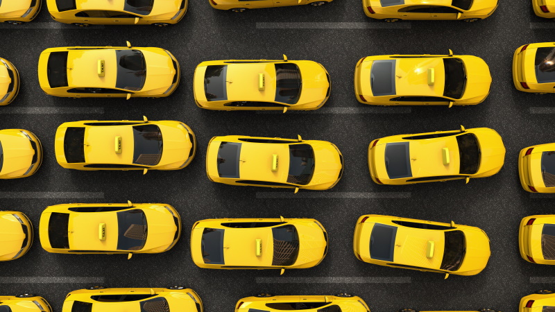 La perturbation comme thème d'investissement: vue aérienne sur une colonne de taxis jaunes bloqués à l'heure de pointe. Un symbole du courant dominant duquel des opportunités sont issues pour la perturbation.