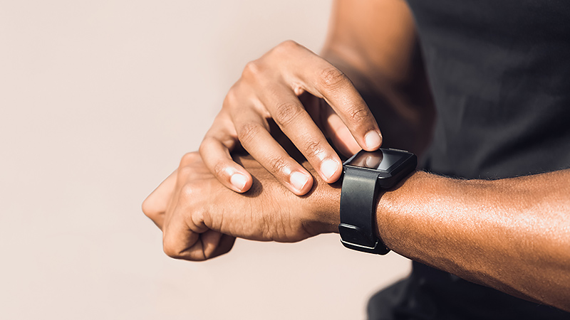 La santé intelligente comme thème d'investissement: la photo en gros plan d'une main avec une montre de fitness illustre comment la surveillance de données de santé en temps réel annonce l'avenir du monde de la santé.