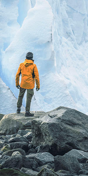 Nachhaltige Wertschöpfung als Megatrend: Ein Mensch vor einer gigantischen Gletscherwand zeigt, wie übermächtig uns die Klimaerwärmung bedroht, wenn wir nicht nachhaltig handeln