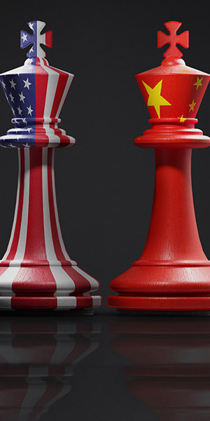 Two chess pieces illustrating current geopolitical tensions: One is painted with the national flag of the USA, the other represents China